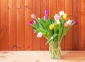 Bouquet of fresh colorful tulips in vase on wooden table Royalty Free Stock Photo
