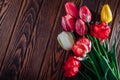 Bouquet of fresh colorful tulips on wooden background. Red, pink, yellow and white flowers. Space Royalty Free Stock Photo