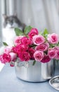 A bouquet of fresh pink roses, in a saucepan made of steel, on a gray stone background. Near the window . Home cat. Free place to Royalty Free Stock Photo