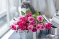 A bouquet of fresh pink roses, in a saucepan made of steel, on a gray stone background. Near the window . Home cat. Free place to Royalty Free Stock Photo