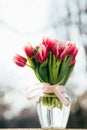 A bouquet of fresh pink tulips in a glass vase outdoors. Bunch of flowers Royalty Free Stock Photo