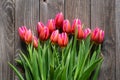 Bouquet of fresh pink tulips on a wooden background, top view. Royalty Free Stock Photo
