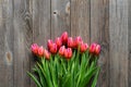 Bouquet of fresh pink tulips on a wooden background, top view. Royalty Free Stock Photo