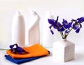 A bouquet of fresh Siberian irises with a yellow and blue napkin on the background of detergents in white bottles, white Royalty Free Stock Photo