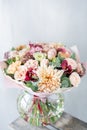 Bouquet of fresh spring flowers on gray wall background. Floral bunch in glass vase. flower shop, florist work Royalty Free Stock Photo