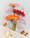 Bouquet of gerberas, bottles of serum and oils and cosmetics accessories