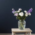 Bouquet of hackelia velutina, purple and white roses, small tea roses, matthiola incana and blue iris in glass vase opposite on Royalty Free Stock Photo