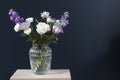 Bouquet of hackelia velutina, purple and white roses, small tea roses, matthiola incana and blue iris in glass vase Royalty Free Stock Photo