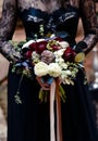 Bouquet in the hands of a girl in a black dress. Magic black, Gothic beauty. Halloween, black widow`s bouquet