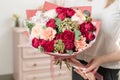 Bouquet of highly red coloured . beautiful luxury bunch of mixed flowers in womans hand. the work of the florist at a Royalty Free Stock Photo