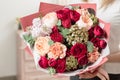 Bouquet of highly red coloured . beautiful luxury bunch of mixed flowers in womans hand. the work of the florist at a Royalty Free Stock Photo