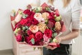 Bouquet of highly red coloured . beautiful luxury bunch of mixed flowers in womans hand. the work of the florist at a Royalty Free Stock Photo