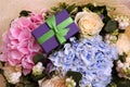 Bouquet of hydrangea and roses with a gift