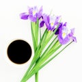 Bouquet of Iris flowers with mug of black coffee on white background. Flat lay, Top view. Royalty Free Stock Photo