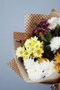 Bouquet in kraft paper. A simple bouquet of flowers and greens on gray background Royalty Free Stock Photo