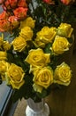 Bouquet with large yellow roses in a white flowerpot by the window in the city shop Royalty Free Stock Photo