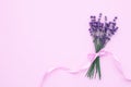 Bouquet of lavender tied with ribbon on a pink paper background, table top view. Fresh flowers blossom. Aromatherapy concept. Flat Royalty Free Stock Photo