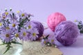A bouquet of lilac chrysanthemums on the background of skeins of multicolored yarn, close - up-the concept of preparing pleasant