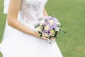 Bouquet of lilac eustoma and milk roses in the hands
