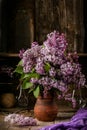 Bouquet of lilac flowers in a ceramic pot on old table Royalty Free Stock Photo