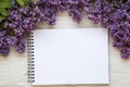 A bouquet of lilac flowers with notebook on a white wooden background. Copy space. Mothers Day. Top view. Royalty Free Stock Photo