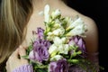 Bouquet with lilac roses and white flowers close-up in the hands of woman in a knitted cardigan Royalty Free Stock Photo