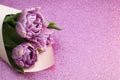 Bouquet of lilac spring tulips and place for text for Mother`s Day on a pink glitter background. Top view flat style