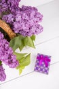 Bouquet of lilac in wicker basket with purple gift box on white Royalty Free Stock Photo