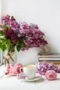 Bouquet of lilacs, cup of coffee, homemade marshmallow. Romantic spring morning