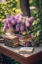 bouquet of lilacs and old books, on a table in the garden in the shade of trees Royalty Free Stock Photo