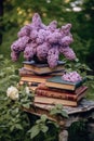 bouquet of lilacs and old books, on a table in the garden in the shade of trees Royalty Free Stock Photo