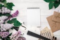 A bouquet of lilacs with violin, letter, notepad and music sheet on a white wooden table. Top wiev with space for your text Royalty Free Stock Photo