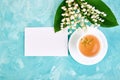 Bouquet of lily of the valley and cup of chamomile tea Royalty Free Stock Photo