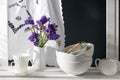 A bouquet of limonium and a set of white dishes: porcelain milk jug, coffee cup, bowls on a white rack on a dark blue background Royalty Free Stock Photo