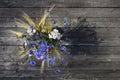 A bouquet of meadow wild flowers, top view, on a dark wooden background Royalty Free Stock Photo