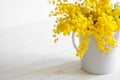 Bouquet of mimosa flowers on white wooden background. Springtime