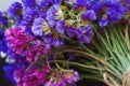 Bouquet of multicolored colors of dry flowers on one-ton background on woven hat made of straw. Violet.