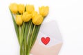 Flowers and hearts lie on a white background. Top view of flat-layed tulips. Open white envelope and red heart. Royalty Free Stock Photo