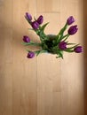 Bouquet of nine purple tulips in a white vase on a wooden background. View from above Royalty Free Stock Photo