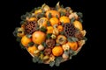 Bouquet of orange, mandarin, persimmon, grapefruit decorated with spruce branches and cones on a black background Royalty Free Stock Photo