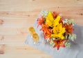 Bouquet of orange and yellow lilies and white hydrangea flowers and glasses of champagne. Top view, copy space