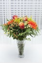 Bouquet of orange, yellow and red flowers in a vase.