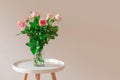 Bouquet of pale pink roses in a glass vase on white table on neutral background wall Royalty Free Stock Photo