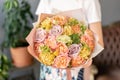 Bouquet Peach and orange color. Beautiful bouquet of mixed flowers in womans hands. the work of the florist at a flower
