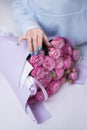 Bouquet of peony roses in a package. The florist creates a beautiful pink bouquet. Flower shop.