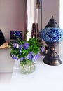 Bouquet of Periwinkle flowers in apartment interior.