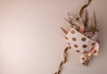 Bouquet pink and beige dried flowers on a beige background with bronze ribbon.