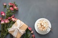 Bouquet of pink bush roses, female gift and cup of coffee on gray, top view point. Copy space. Royalty Free Stock Photo