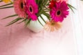 Bouquet of pink daisies in white vase on pink background, colorful flowers view above Royalty Free Stock Photo