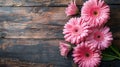 A bouquet of pink gerbera daisies laid on a wooden surface, created by Generative AI